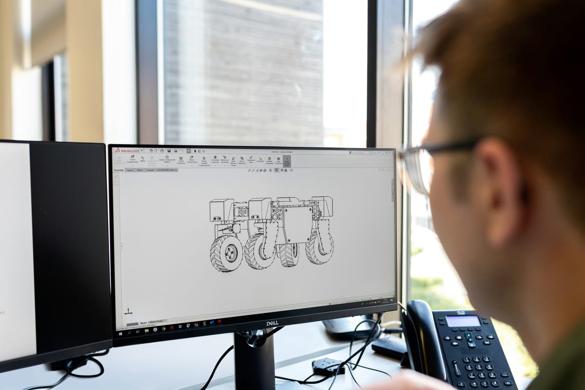 Konstrukteur an einer CAD-Zeichnung: Baugruppe eines Fahrzeugs – Konstruktionsarbeit als förderfähige Forschung